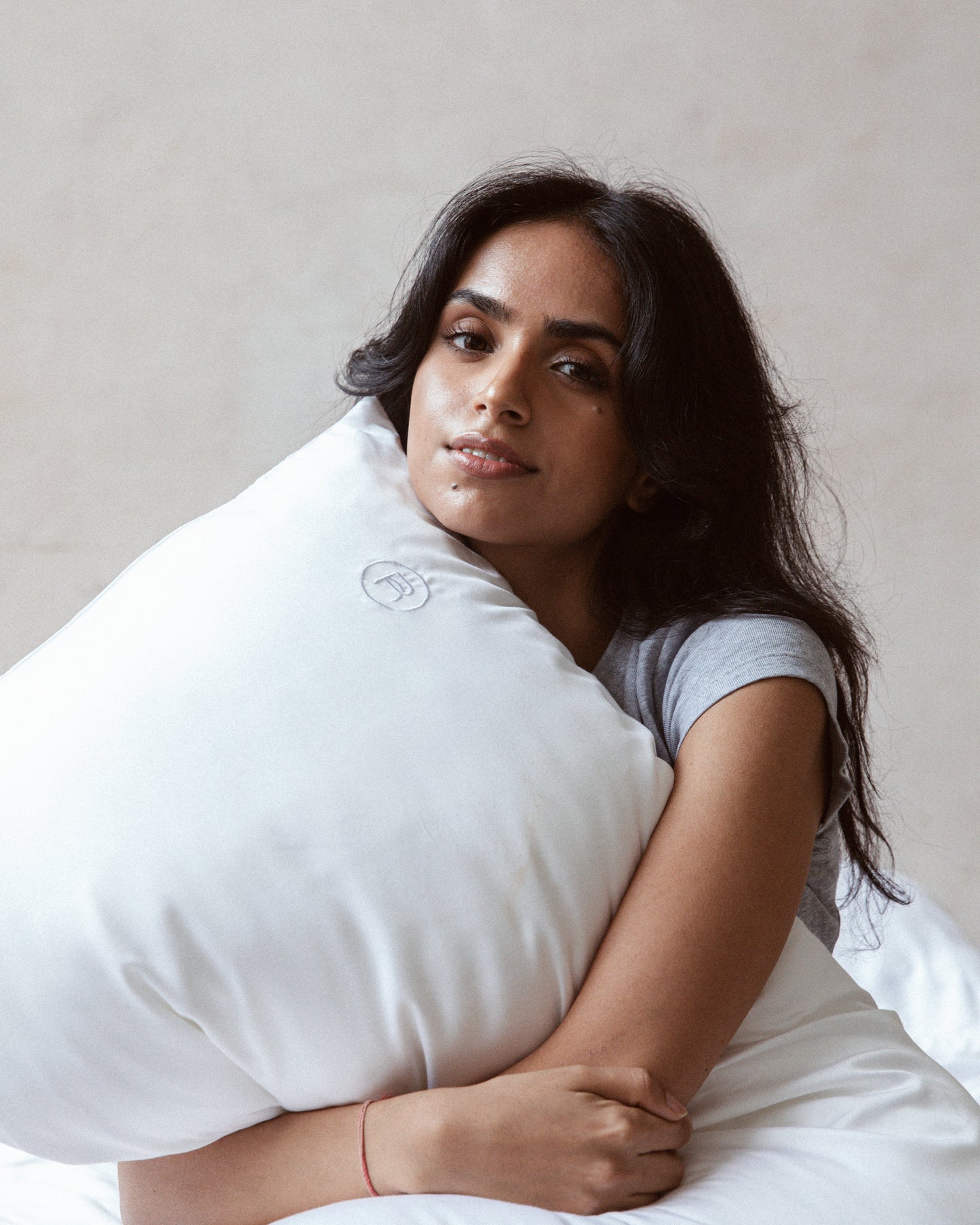 female model hugging white pillow with restday white pillowcase