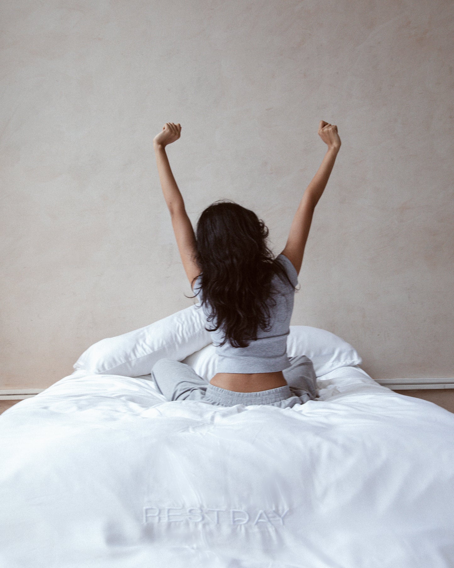 female model stretching on restday white bamboo sheets