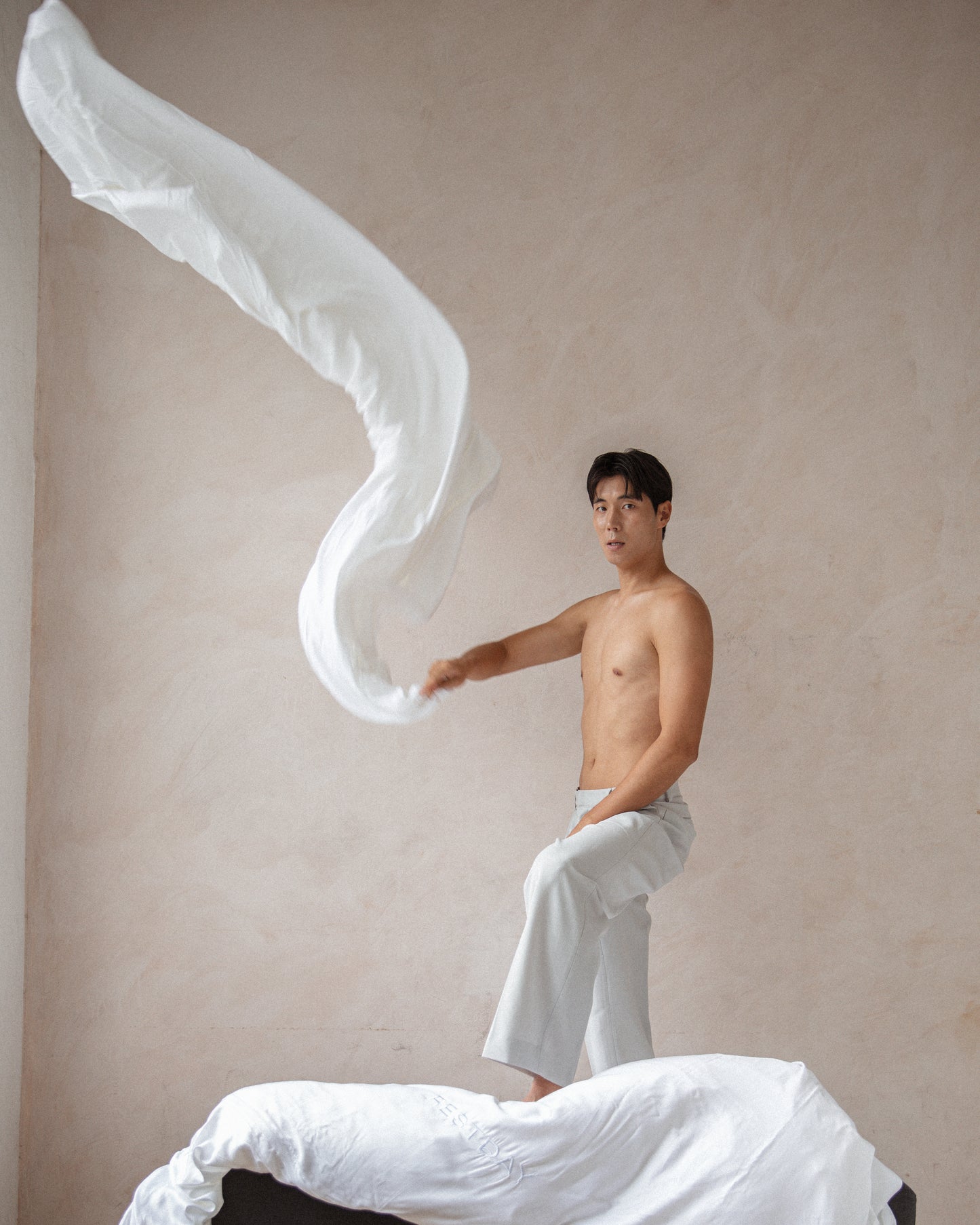 Male asian model holding restday sheets in the air