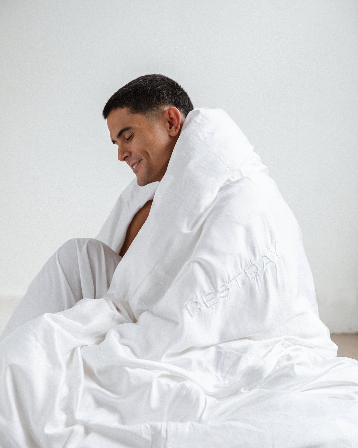 Male model smiling in restday bamboo bed sheets